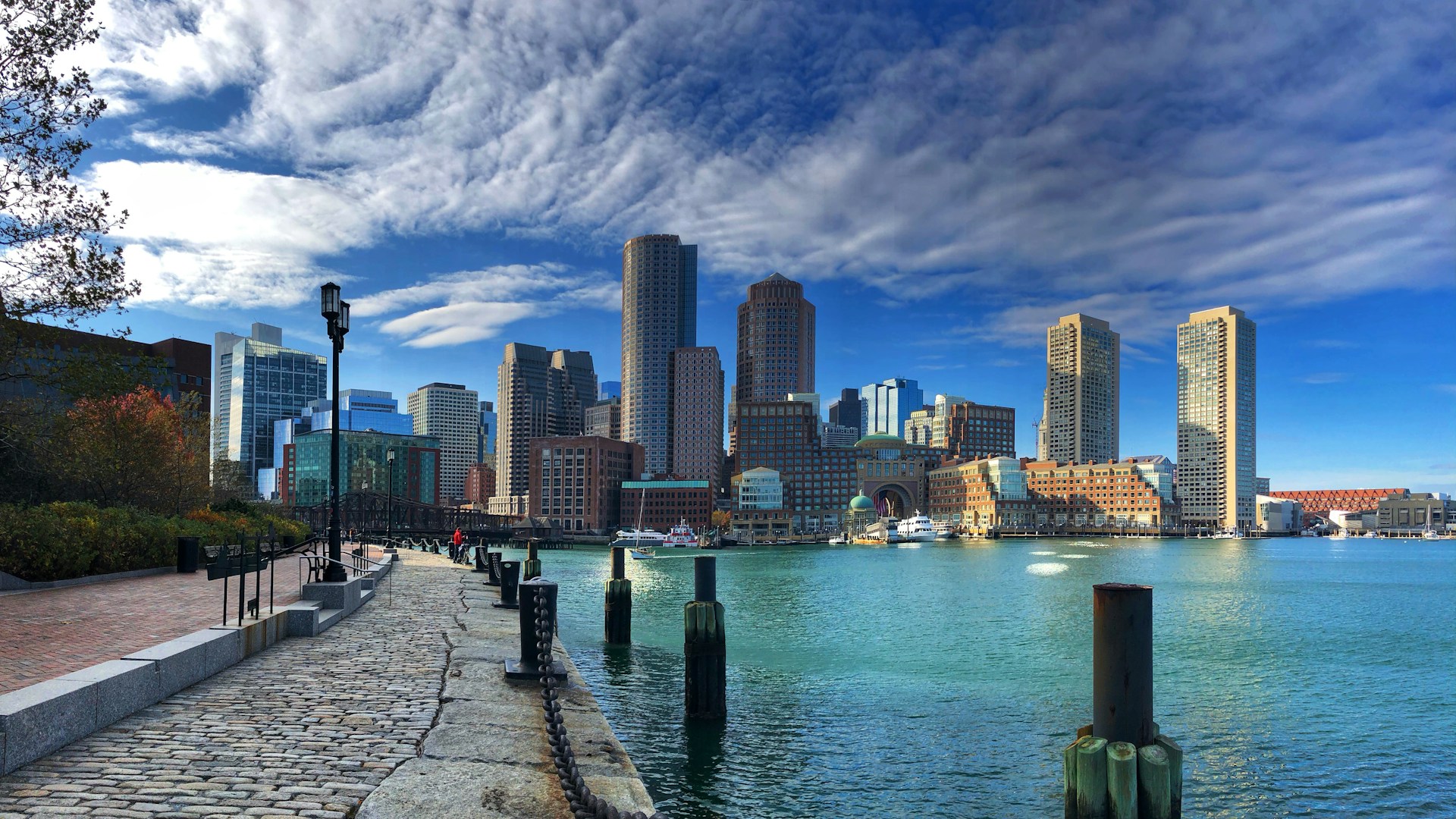A city skyline with a body of water and a dock, reflecting the urban landscape and business opportunities in Boston.